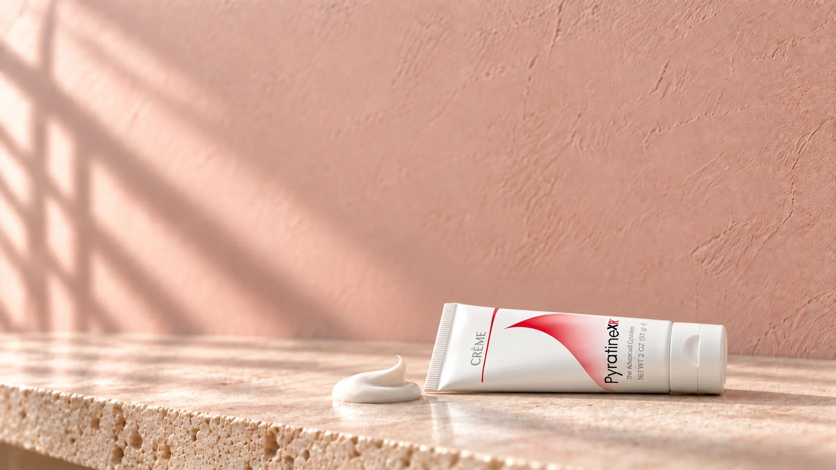 The PyratineXR Crème tube lying on the stone shelf beside a swirl of crème